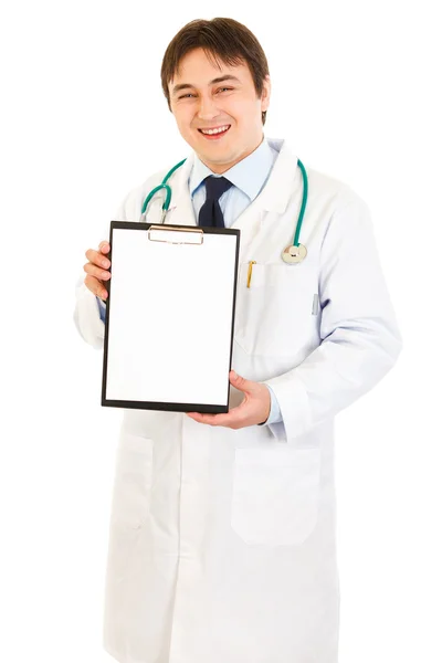 Médico sorridente segurando prancheta em branco — Fotografia de Stock