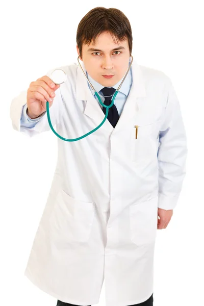 Концентрированный врач держит стетоскоп — стоковое фото