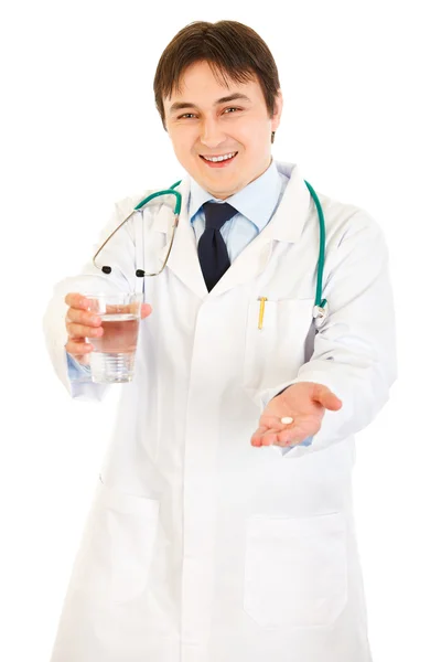 Улыбающийся врач с лекарством и стаканом воды в руках — стоковое фото