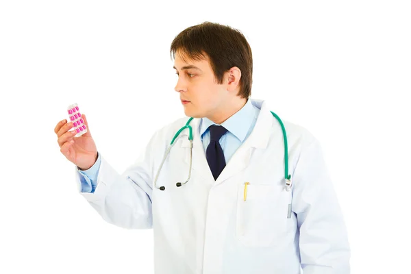 Skoncentrowany lekarz patrząc na opakowanie tabletek — Zdjęcie stockowe