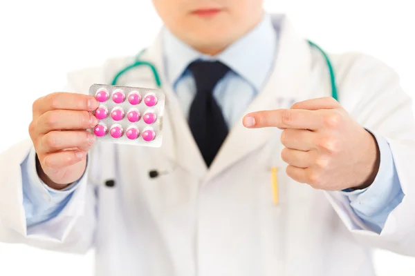 Lékař ukazováčkem na krabičku pilulek. detail. — Stock fotografie
