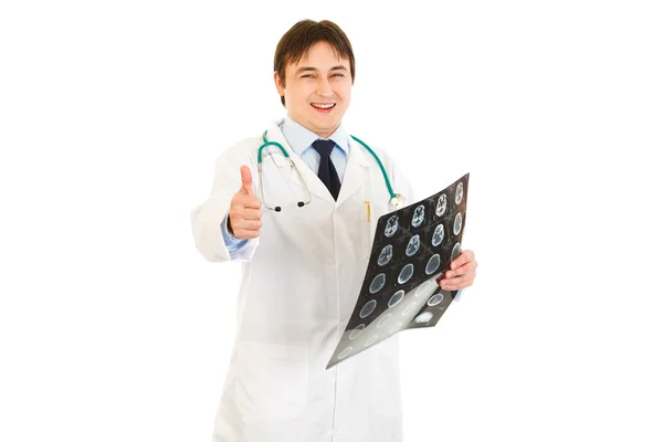 Médico sonriente sosteniendo la tomografía y mostrando los pulgares hacia arriba gesto —  Fotos de Stock