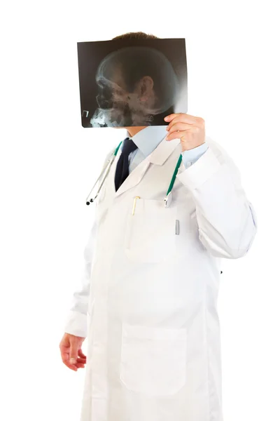Médico sonriente sosteniendo cabezas roentgen delante de su cabeza — Foto de Stock