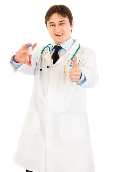Smiling medical doctor holding blood sample and showing thumbs up gesture — Stock Photo, Image