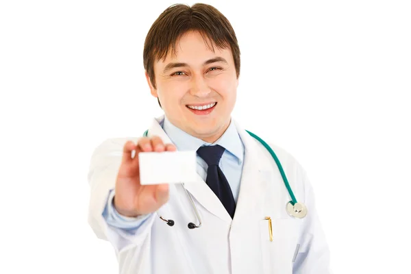 Smiling medical doctor holding blank business card in hand — Stock Photo, Image