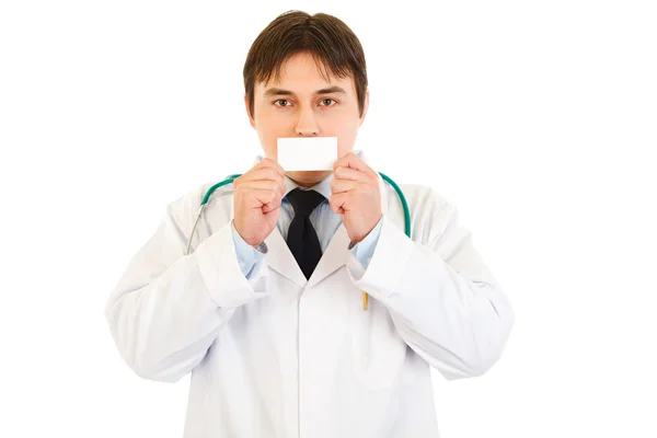 Médico segurando cartão de visita em branco na frente da boca — Fotografia de Stock