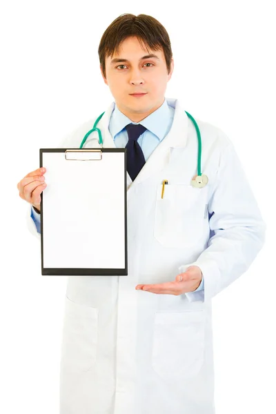 Authoritative medical doctor pointing at blank clipboard — Stock Photo, Image