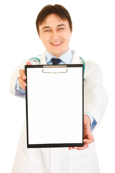 Médico sonriente sosteniendo el portapapeles en blanco en las manos — Foto de Stock