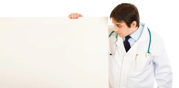 Arzt schaut auf leere Plakatwand — Stockfoto