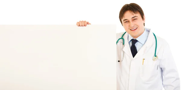 Médico sonriente sosteniendo cartelera en blanco — Foto de Stock