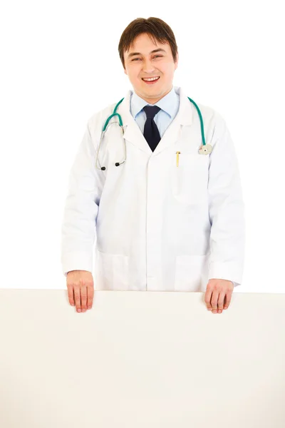 Leende läkare håller Tom billboard i händer — Stockfoto