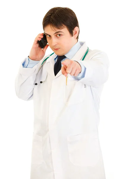 Medical doctor talking on mobile phone and pointing finger at you — Stock Photo, Image