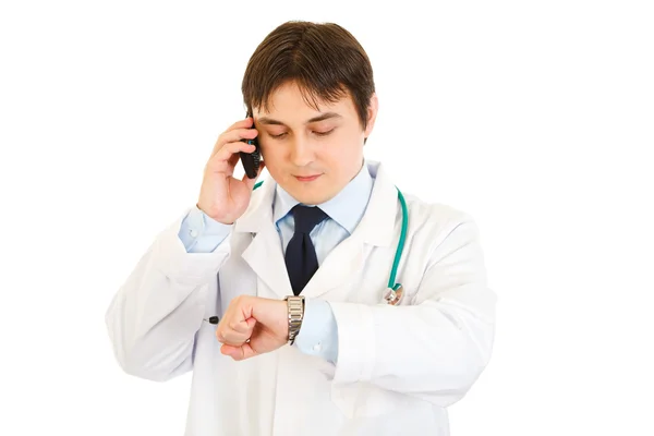 Orvos beszél a mobil, és az óráját nézte — Stock Fotó