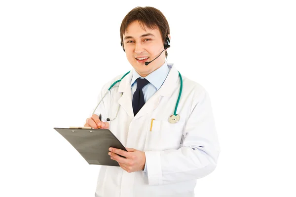 Médico sonriente con auriculares sujetando el portapapeles en la mano — Foto de Stock