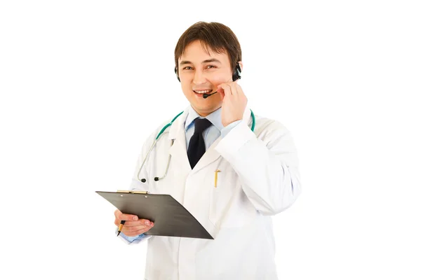 Médico sonriente con auriculares sujetando el portapapeles en la mano — Foto de Stock