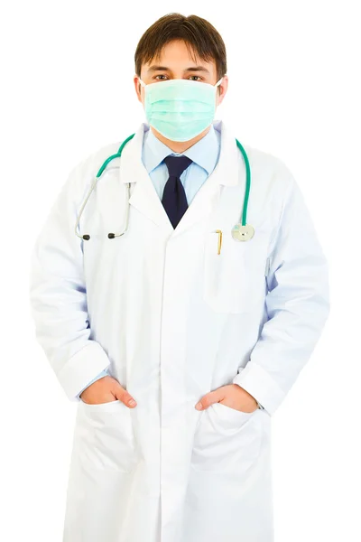 Medical doctor with mask on face holding hands in pockets — Stock Photo, Image