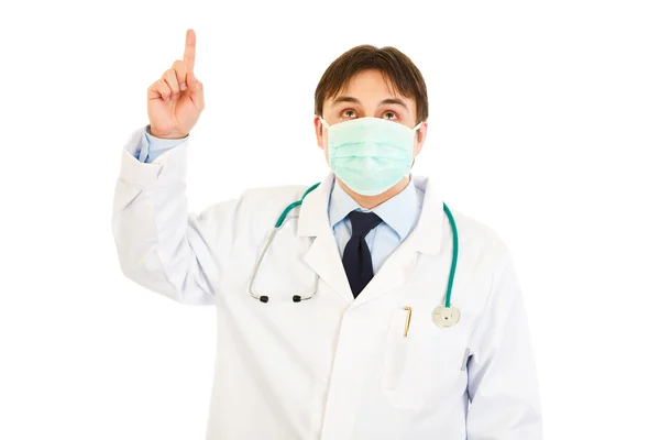 Medical doctor in mask pointing finger up — Stock Photo, Image