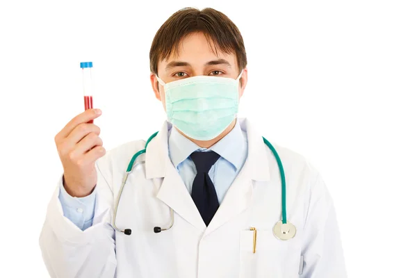 Medical doctor in mask holding blood sample in hand — Stock Photo, Image