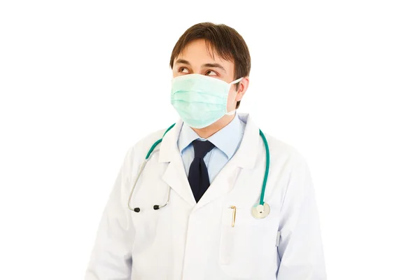 Medical doctor in mask looking up at copy space — Stock Photo, Image