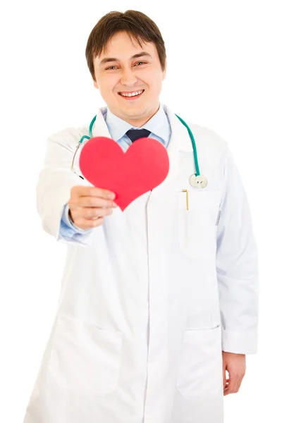 Smiling medical doctor holding paper heart in hand — Stock Photo, Image