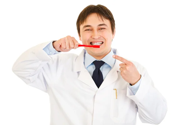Χαμογελώντας οδοντίατρος δάχτυλο που δείχνει την οδοντόβουρτσα. έννοια - υγιεινό δόντια — Φωτογραφία Αρχείου