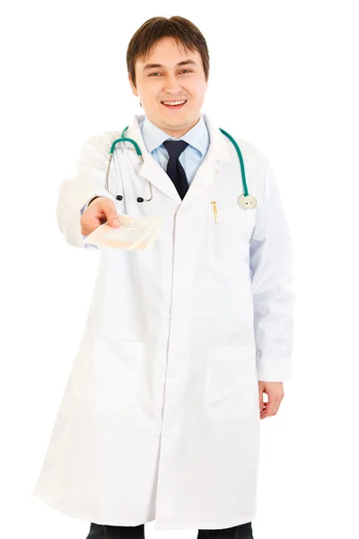 Médico sonriente dando prescripción médica en la mano — Foto de Stock