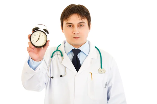 Serious medical doctor holding alarm clock in hand — Stock Photo, Image