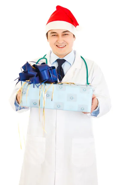 Smiling medical doctor in Santa hat holding present in hands — Stock Photo, Image