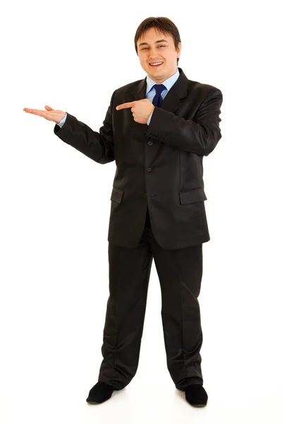 Full length portrait of smiling modern businessman pointing finger on empty Royalty Free Stock Photos