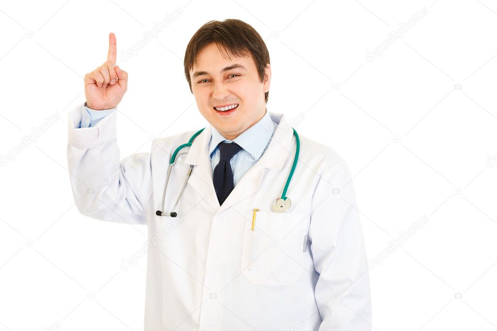 Smiling young medical doctor pointing finger up