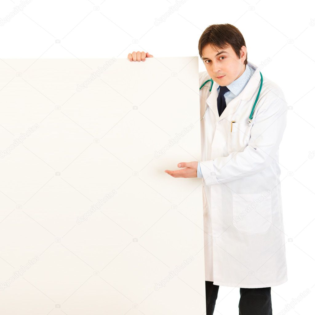 Authoritative medical doctor pointing on blank billboard