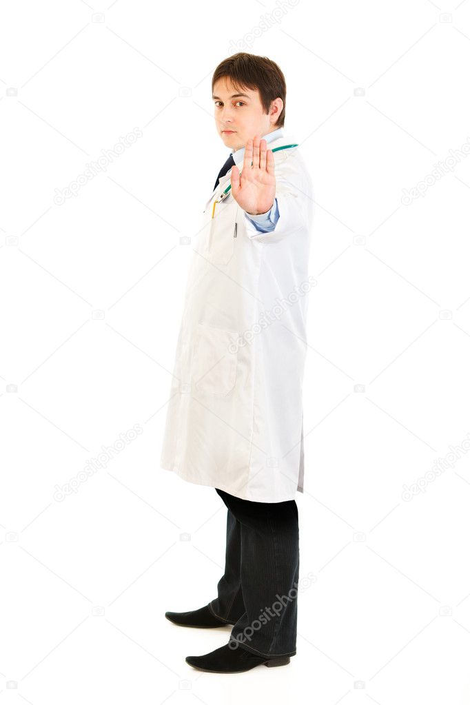 Full length portrait of authoritative medical doctor showing stop gesture
