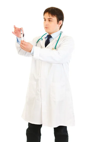 Médico serio sosteniendo la jeringa médica en la mano —  Fotos de Stock