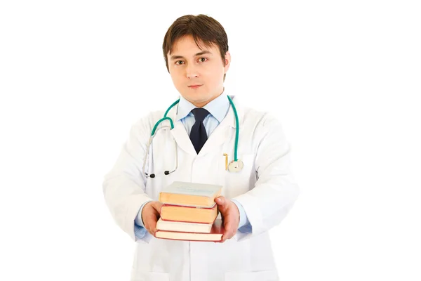 Улыбающийся доктор держит в руках несколько медицинских книг — стоковое фото