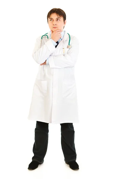 Médico reflexivo sosteniendo la mano cerca de la barbilla y mirando en la esquina en spac copia —  Fotos de Stock