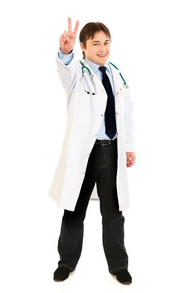 Retrato de cuerpo entero del médico sonriente mostrando gesto de victoria — Foto de Stock
