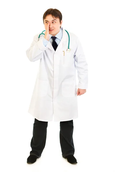 Ganzkörperporträt eines lächelnden Arztes, der seine Hand in Mundnähe hält — Stockfoto