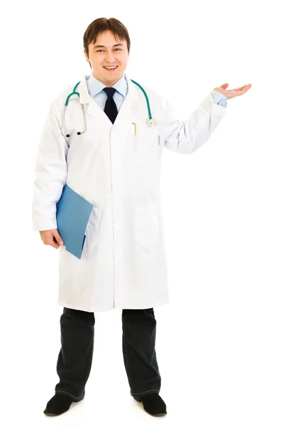 Full length portrait of doctor holding medical chart and presenting somethi — Stock Photo, Image