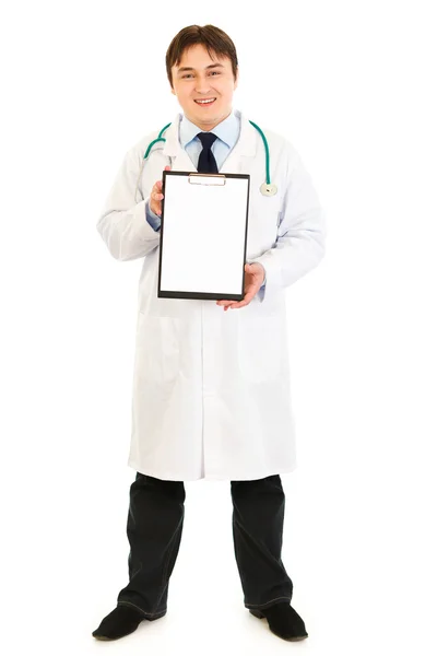 Médico sonriente sosteniendo portapapeles en blanco — Foto de Stock