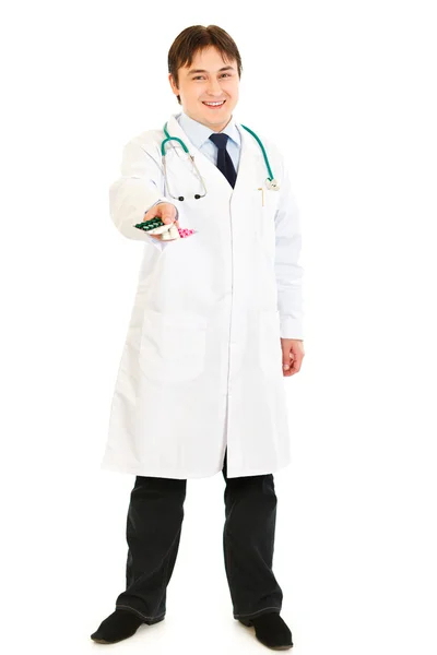 Médico sonriente sosteniendo paquetes de pastillas en la mano — Foto de Stock