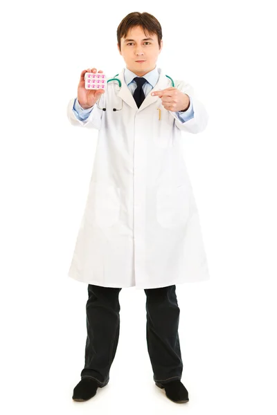 Seriöser Arzt zeigt mit dem Finger auf Tablettenpackung — Stockfoto