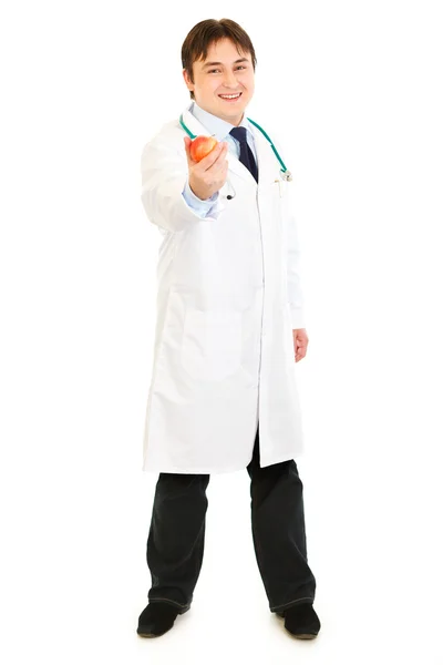 Ganzkörperporträt eines lächelnden Arztes mit Apfel in der Hand — Stockfoto