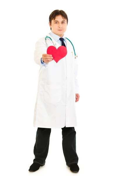 Χαμογελώντας ιατρός κρατώντας καρδιά χαρτί στο χέρι — Φωτογραφία Αρχείου