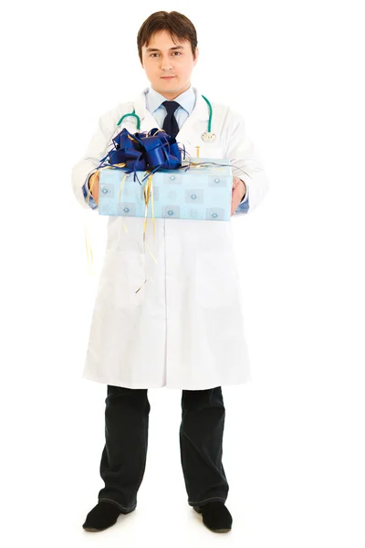 Médico sonriente sosteniendo regalo en las manos — Foto de Stock