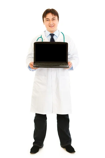 Uśmiechnięty doktor trzymając laptop rezygnować pusty ekran w ręce — Zdjęcie stockowe