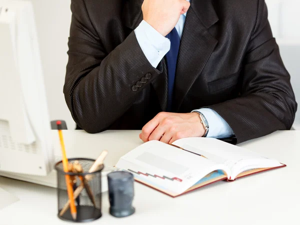 Affärsman sitter på skrivbord med dagbok. närbild — Stockfoto