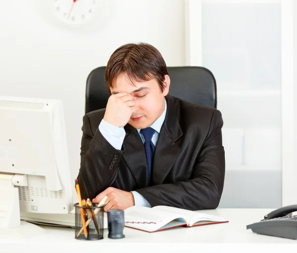 Cansado homem de negócios moderno sentado na mesa de escritório — Fotografia de Stock