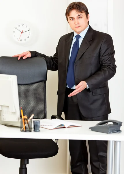 フレンドリーな近代的な実業家のオフィスの椅子の上に座るに招待 — ストック写真