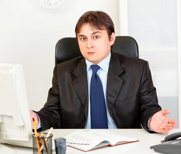 Confundido empresario moderno sentado en el escritorio de la oficina — Foto de Stock