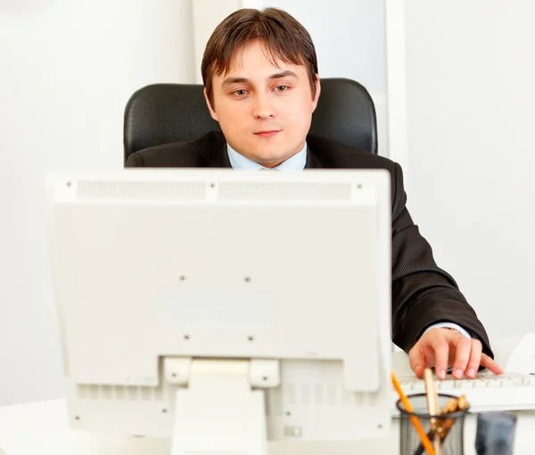 Hombre de negocios moderno sentado en el escritorio de la oficina y trabajando en la computadora — Foto de Stock
